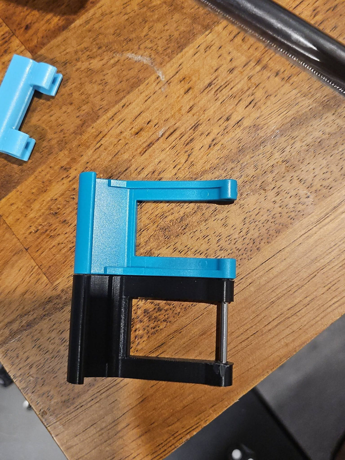 3D-printed Lovesac recliner latch replacement next to the original factory part